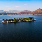 Aerial image taken from a drone of Nehru Garden on Fateh Sagar Lake Udaipur, Rajasthan, India with mountains in the background