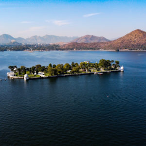 Aerial image taken from a drone of Nehru Garden on Fateh Sagar Lake Udaipur, Rajasthan, India with mountains in the background