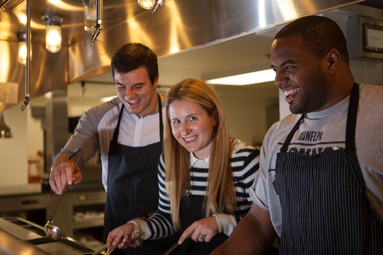 Ryan Kerrigan, Laura Wainman and Darrel Young mix it up in the Redskins’ kitchen. (Photo by Jay Snap)